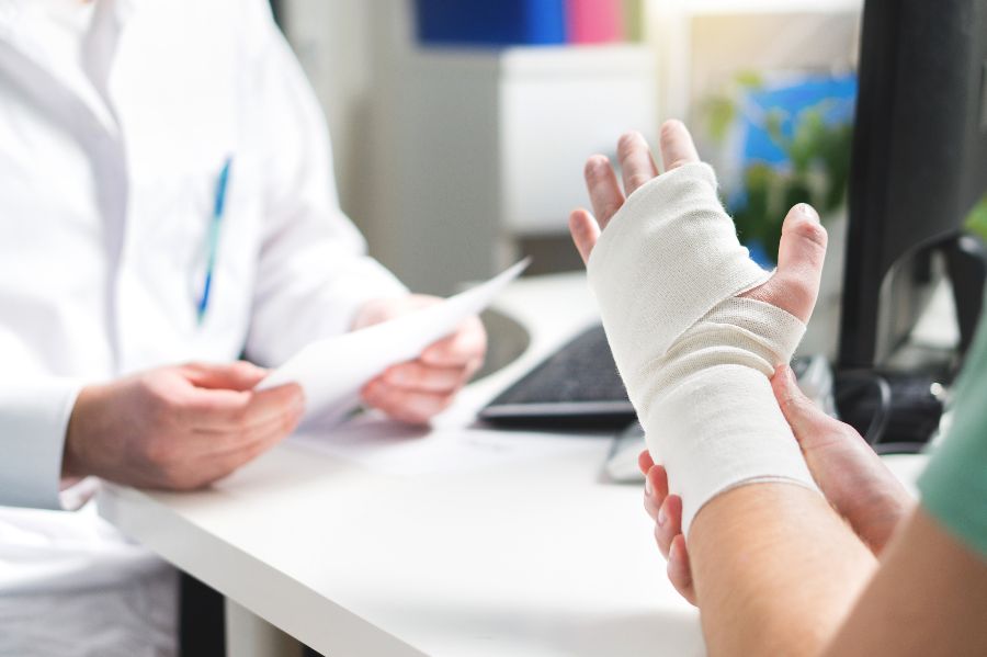 A doctor examines a patient with a broken wrist